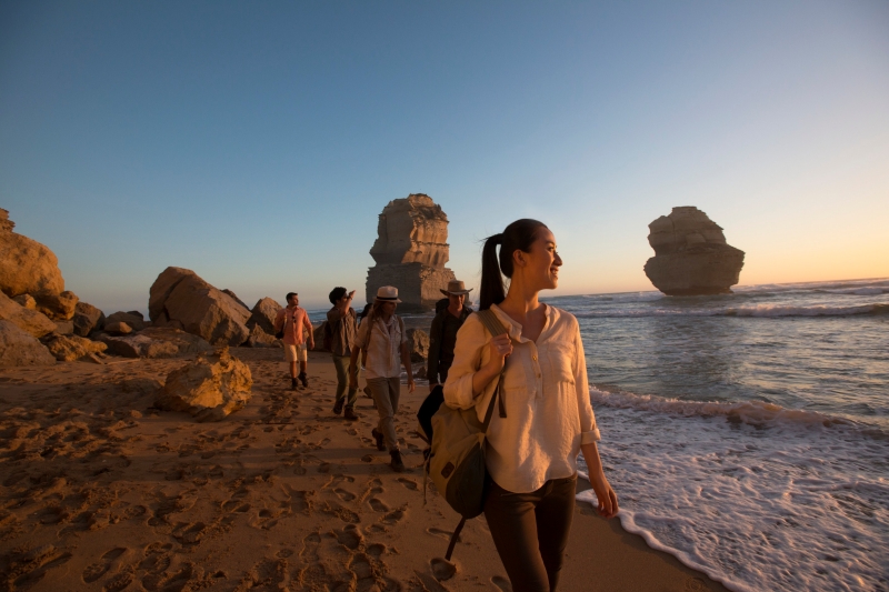 A group walks on the beach admiring the Twelve Apostles, Victoria © Tourism Australia